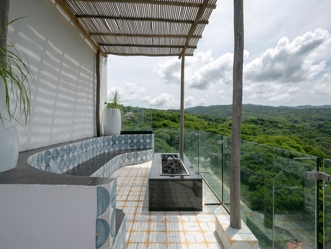 Rooftop terrace at El Cielo de Sayulita with tiled seating, fire feature and jungle views